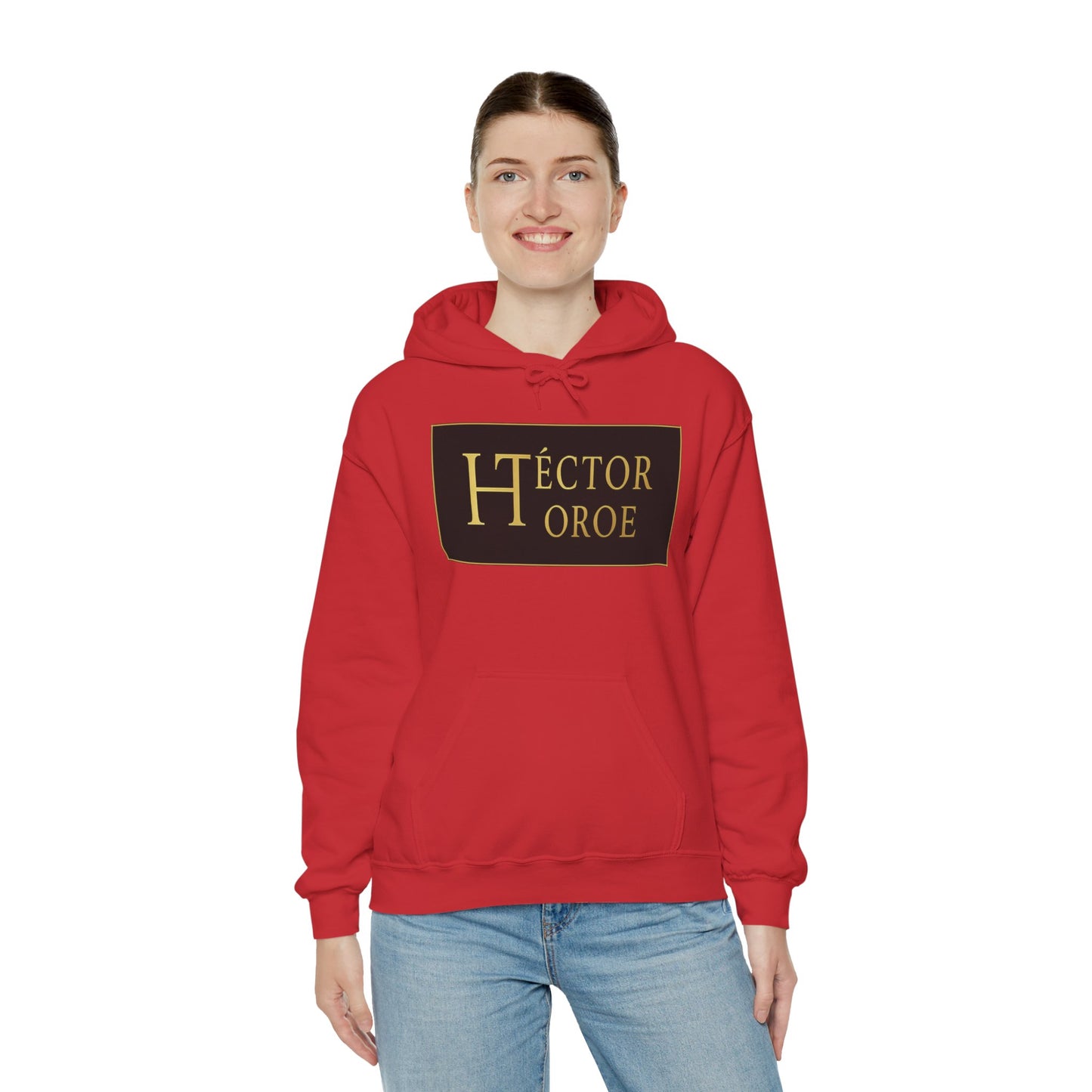 una mujer con sudadera rojo con capucha y bolsillo frontal, con un logotipo rectangular negro y dorado en el centro que muestra el texto “Héctor Toroe”.