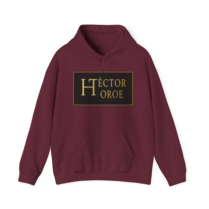 Sudadera granate con capucha y bolsillo frontal, con un logotipo rectangular negro y dorado en el centro que muestra el texto “Héctor Toroe”.