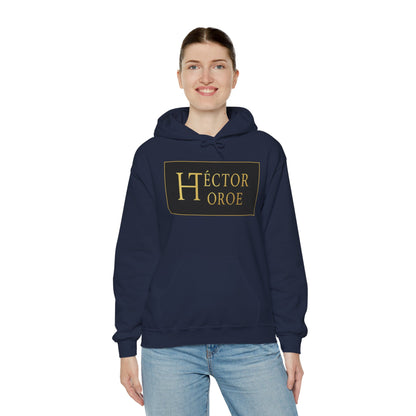 una mujer con sudadera azul marino con capucha y bolsillo frontal, con un logotipo rectangular negro y dorado en el centro que muestra el texto “Héctor Toroe”. 