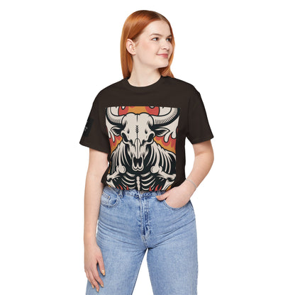 Mujer usando una camiseta cafe de manga corta con un diseño gráfico central de una calavera de toro con cuernos, estilo ilustración, sobre un fondo de llamas en tonos rojo, naranja y negro.