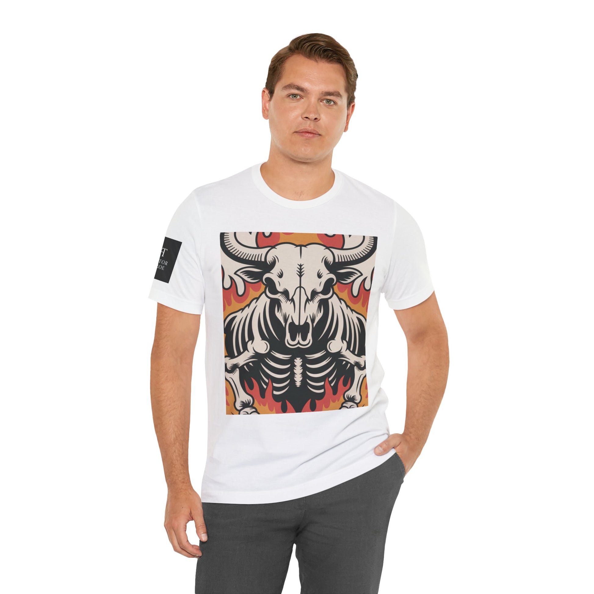 Hombre usando una camiseta blanca de manga corta con un diseño gráfico central de una calavera de toro con cuernos, estilo ilustración, sobre un fondo de llamas en tonos rojo, naranja y negro.