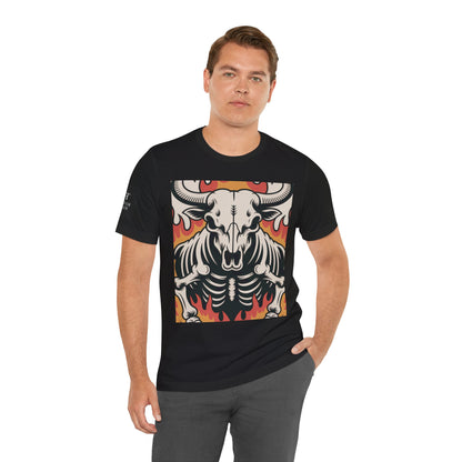 Hombre usando una camiseta negro de manga corta con un diseño gráfico central de una calavera de toro con cuernos, estilo ilustración, sobre un fondo de llamas en tonos rojo, naranja y negro.